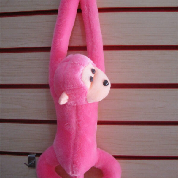 Peluche rose réaliste d'un singe amoureux de câlins